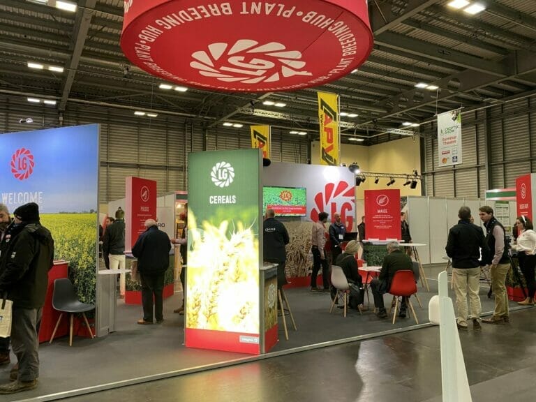 croptec show stand with large circular red lg graphic hanging from the ceiling, lightboxes with crop photos and members of the public milling around.
